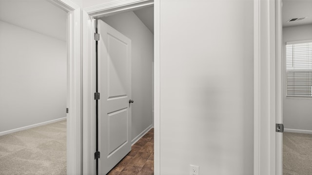 corridor with visible vents, baseboards, and carpet floors