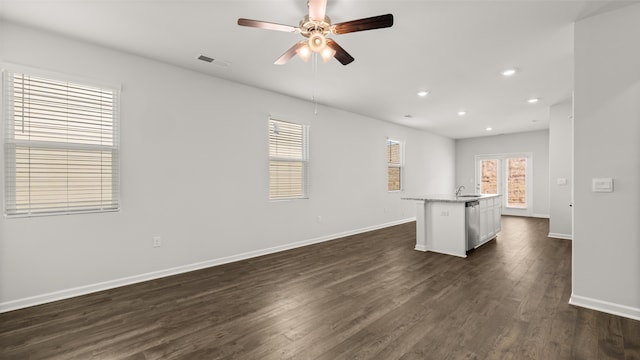 unfurnished living room featuring dark wood-type flooring, a ceiling fan, a sink, recessed lighting, and baseboards