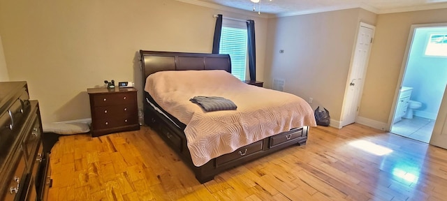 bedroom featuring connected bathroom, light hardwood / wood-style flooring, multiple windows, and ornamental molding