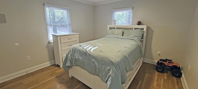 bedroom with hardwood / wood-style flooring and ornamental molding