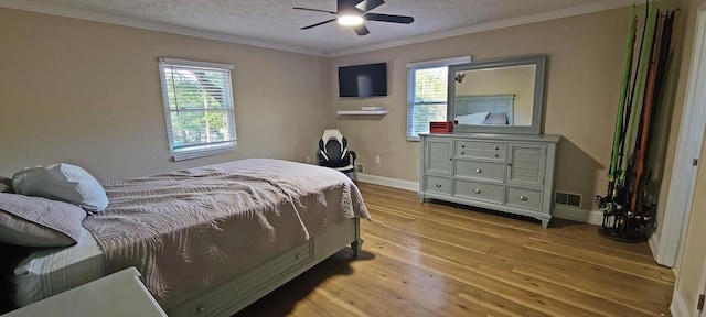 bedroom featuring ceiling fan, ornamental molding, a textured ceiling, and light hardwood / wood-style flooring