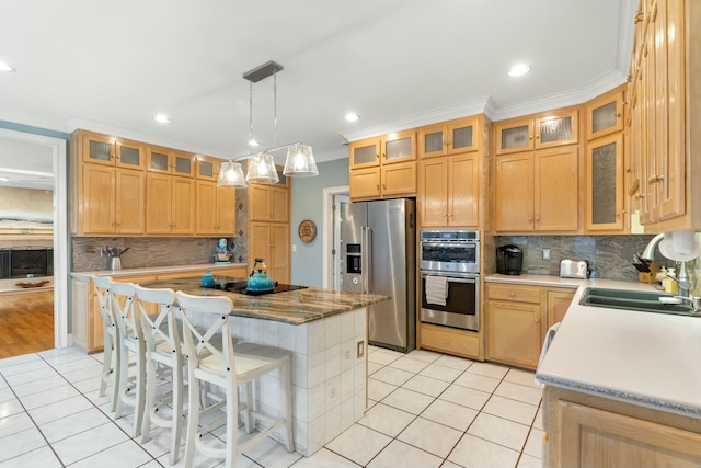 kitchen featuring glass insert cabinets, appliances with stainless steel finishes, and a center island