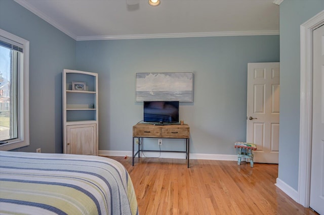 bedroom with multiple windows, baseboards, and wood finished floors