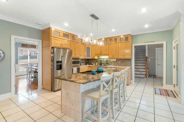 kitchen featuring light tile patterned flooring, glass insert cabinets, stainless steel appliances, and a center island