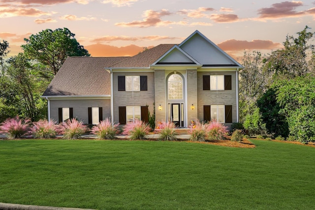 view of front of house featuring roof with shingles and a front lawn