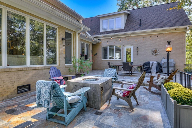 view of patio with an outdoor fire pit and a grill