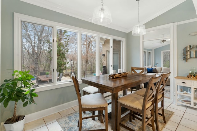 dining room with lofted ceiling, ornamental molding, a ceiling fan, light tile patterned flooring, and baseboards