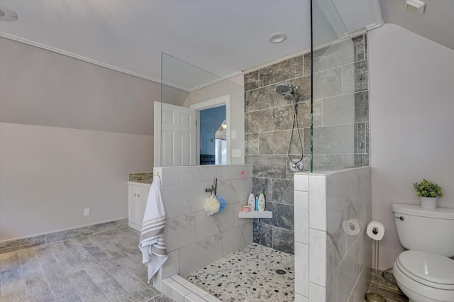 bathroom featuring wood finished floors, vaulted ceiling, toilet, and a walk in shower