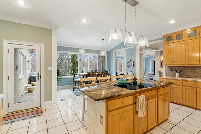 kitchen featuring light tile patterned floors, a kitchen island, a kitchen breakfast bar, black electric stovetop, and pendant lighting