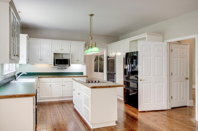 4142 Rivermont Dr, Evans, GA 30809 - kitchen with black appliances, white cabinetry, light wood-style flooring, a kitchen island, and pendant lighting
