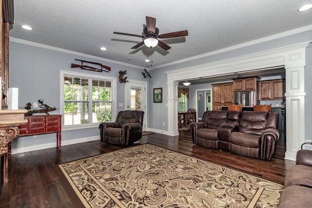 living room featuring ornate columns, ceiling fan, dark hardwood / wood-style floors, a textured ceiling, and ornamental molding