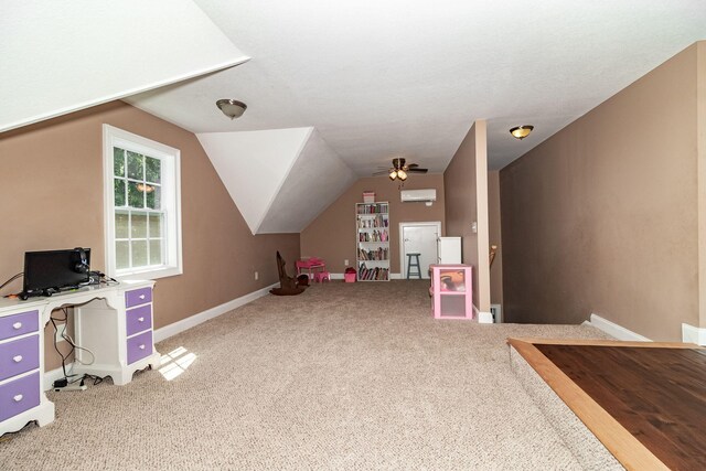 game room with carpet flooring, vaulted ceiling, a wall unit AC, and ceiling fan