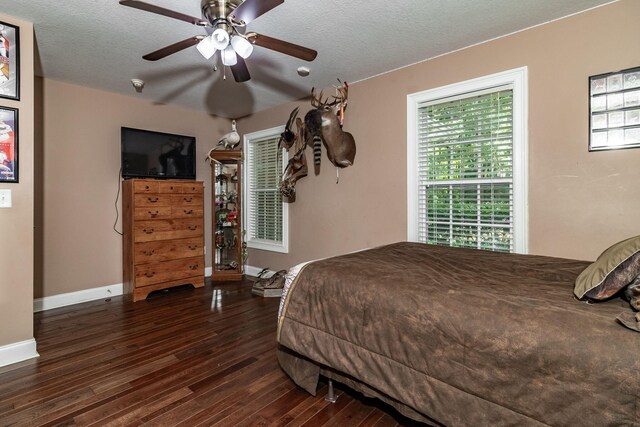 bedroom with ceiling fan, dark hardwood / wood-style floors, and a textured ceiling