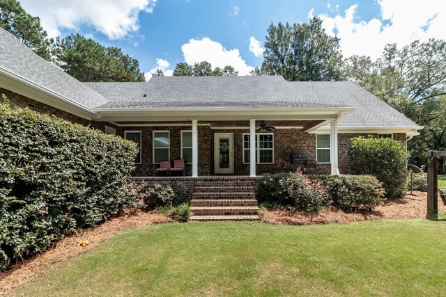 back of house featuring a porch and a yard