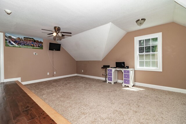 additional living space with a textured ceiling, carpet floors, ceiling fan, and lofted ceiling