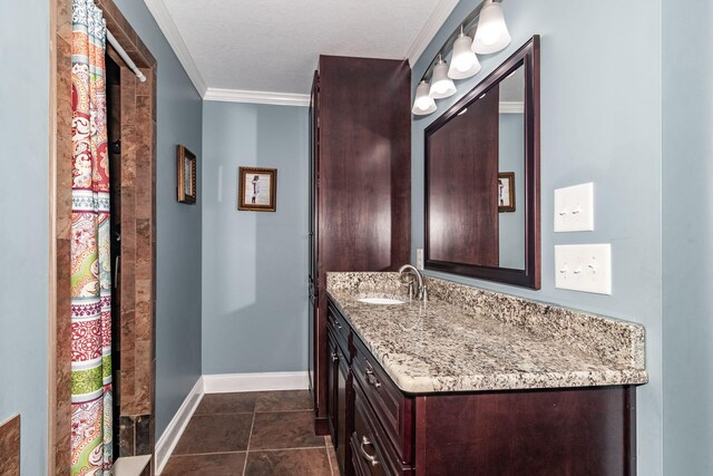 bathroom with tile patterned flooring, a textured ceiling, vanity, and ornamental molding