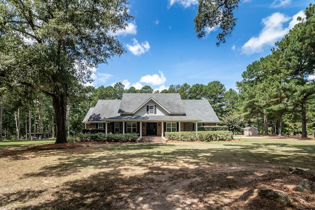 view of front of house with a storage shed and a front yard