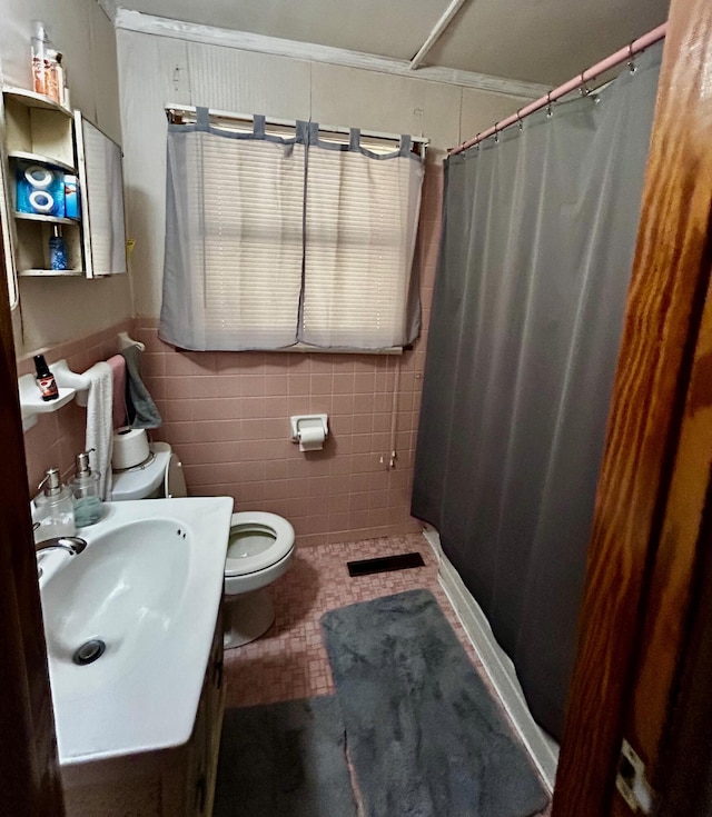 412 W 9th St, Waynesboro, GA 30830 - bathroom with toilet, vanity, curtained shower, tile patterned flooring, and tile walls