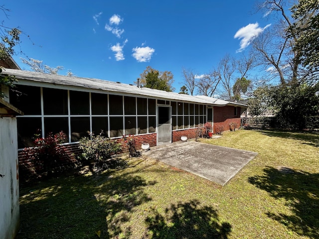 412 W 9th St, Waynesboro, GA 30830 - rear view of house featuring a lawn, a sunroom, and a patio