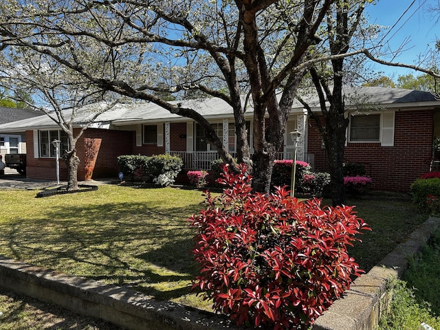412 W 9th St, Waynesboro, GA 30830 - view of front of house featuring covered porch, brick siding, and a front lawn
