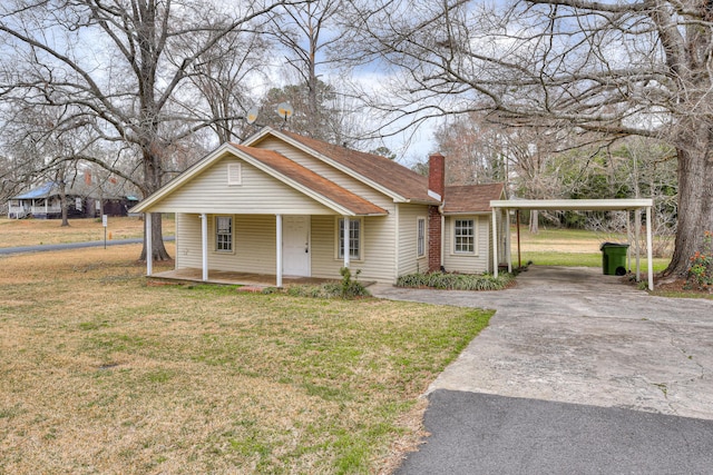 bungalow-style home with a porch, a front yard, a chimney, a carport, and driveway