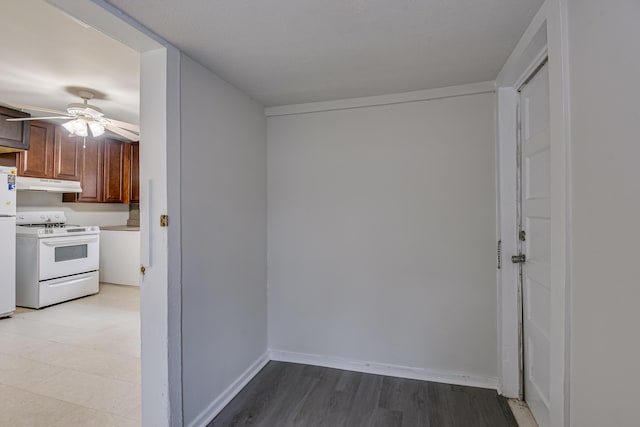 interior space with baseboards, a ceiling fan, and light wood finished floors