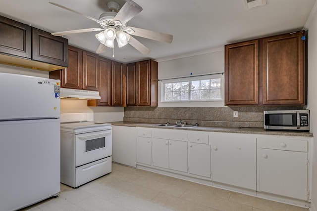 kitchen with white appliances, visible vents, a sink, under cabinet range hood, and white cabinetry