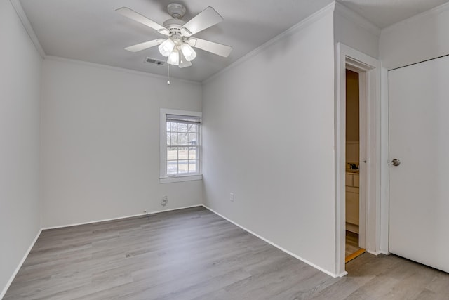 spare room with visible vents, a ceiling fan, crown molding, and light wood finished floors