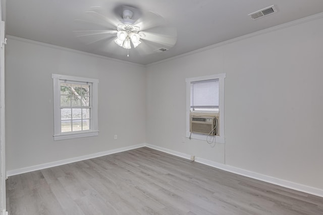 unfurnished room with wood finished floors, a ceiling fan, visible vents, and ornamental molding