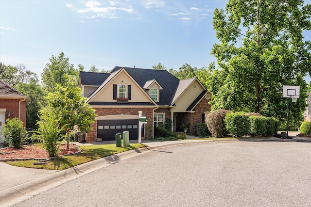 traditional-style house with brick siding, a garage, concrete driveway, and stucco siding