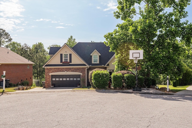 traditional home with brick siding, driveway, and an attached garage