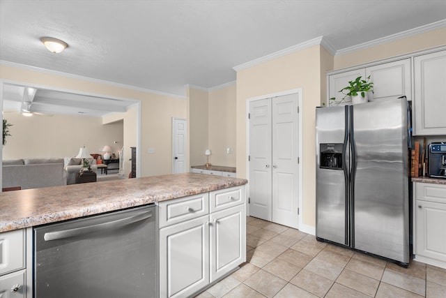 kitchen featuring appliances with stainless steel finishes, light tile patterned flooring, crown molding, light countertops, and open floor plan