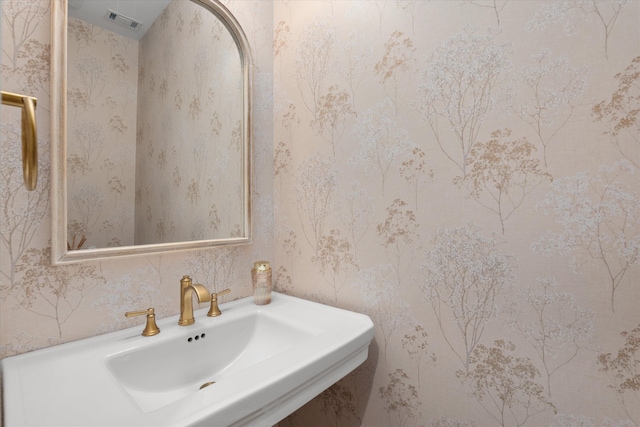 bathroom with a sink and wallpapered walls