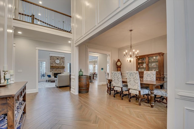 649 Bent Creek Dr, Evans, GA 30809 - dining room with a brick fireplace, a high ceiling, baseboards, and a chandelier