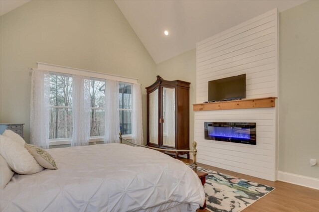 649 Bent Creek Dr, Evans, GA 30809 - bedroom with high vaulted ceiling, a glass covered fireplace, wood finished floors, recessed lighting, and baseboards