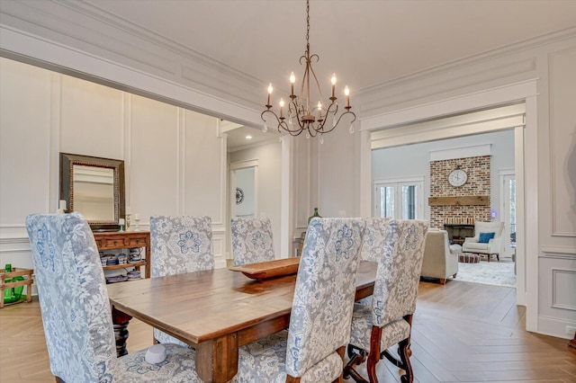 649 Bent Creek Dr, Evans, GA 30809 - dining area featuring a decorative wall, a fireplace, crown molding, and an inviting chandelier