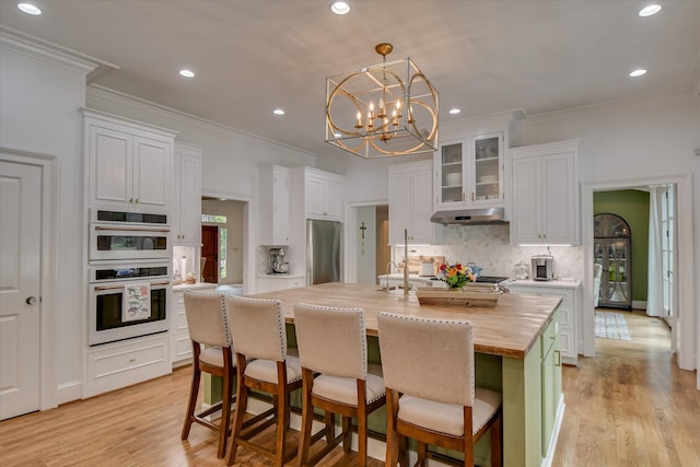 704 Summergate Ct, Augusta, GA 30909 - kitchen with wood counters, under cabinet range hood, white double oven, freestanding refrigerator, and decorative backsplash
