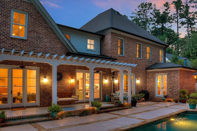 704 Summergate Ct, Augusta, GA 30909 - back of property at dusk with a patio area, brick siding, an outdoor pool, and a pergola