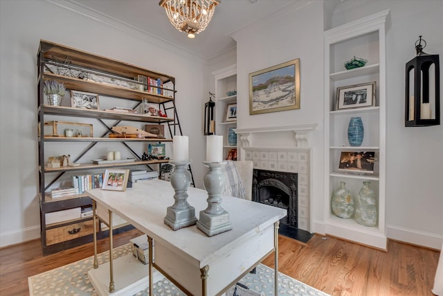 704 Summergate Ct, Augusta, GA 30909 - office area with wood finished floors, ornamental molding, built in features, a chandelier, and a tile fireplace