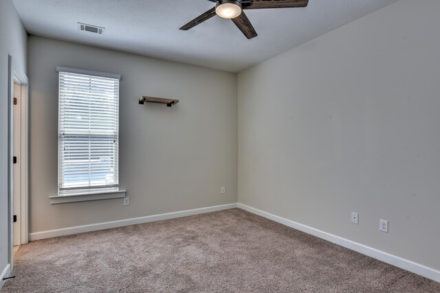 spare room featuring light carpet and ceiling fan