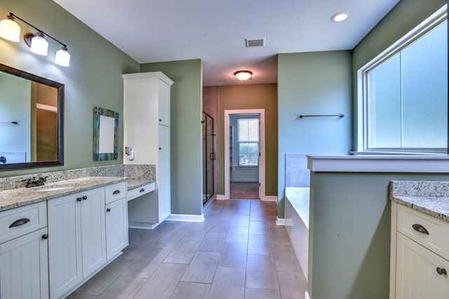 bathroom with vanity and shower with separate bathtub