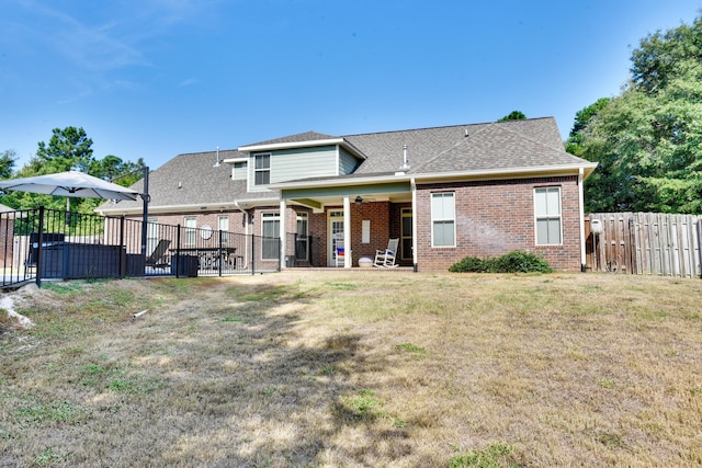 back of property with a lawn and ceiling fan