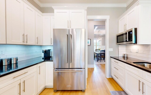 243 Walton Heath Way, Aiken, SC 29803 - kitchen featuring appliances with stainless steel finishes, dark countertops, white cabinetry, tasteful backsplash, and ornamental molding