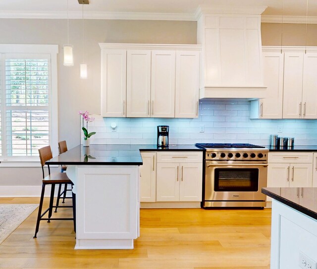 243 Walton Heath Way, Aiken, SC 29803 - kitchen with high end stainless steel range, dark countertops, a breakfast bar, light wood-type flooring, and white cabinetry