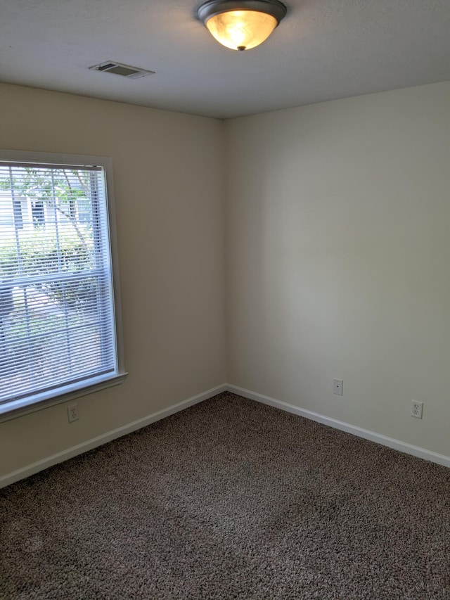 spare room with visible vents, baseboards, and carpet floors