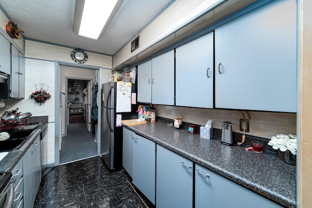 kitchen featuring a textured ceiling, sink, and stainless steel appliances