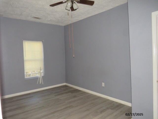 empty room featuring a textured ceiling, ceiling fan, wood finished floors, and baseboards