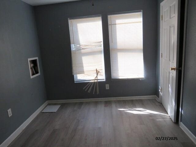 empty room with baseboards and wood finished floors