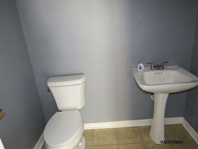 bathroom featuring tile patterned flooring, baseboards, and toilet