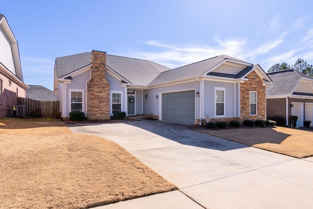 ranch-style house featuring a garage and cooling unit